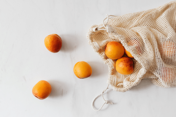 a bag with apricots and and apricots laying on a table