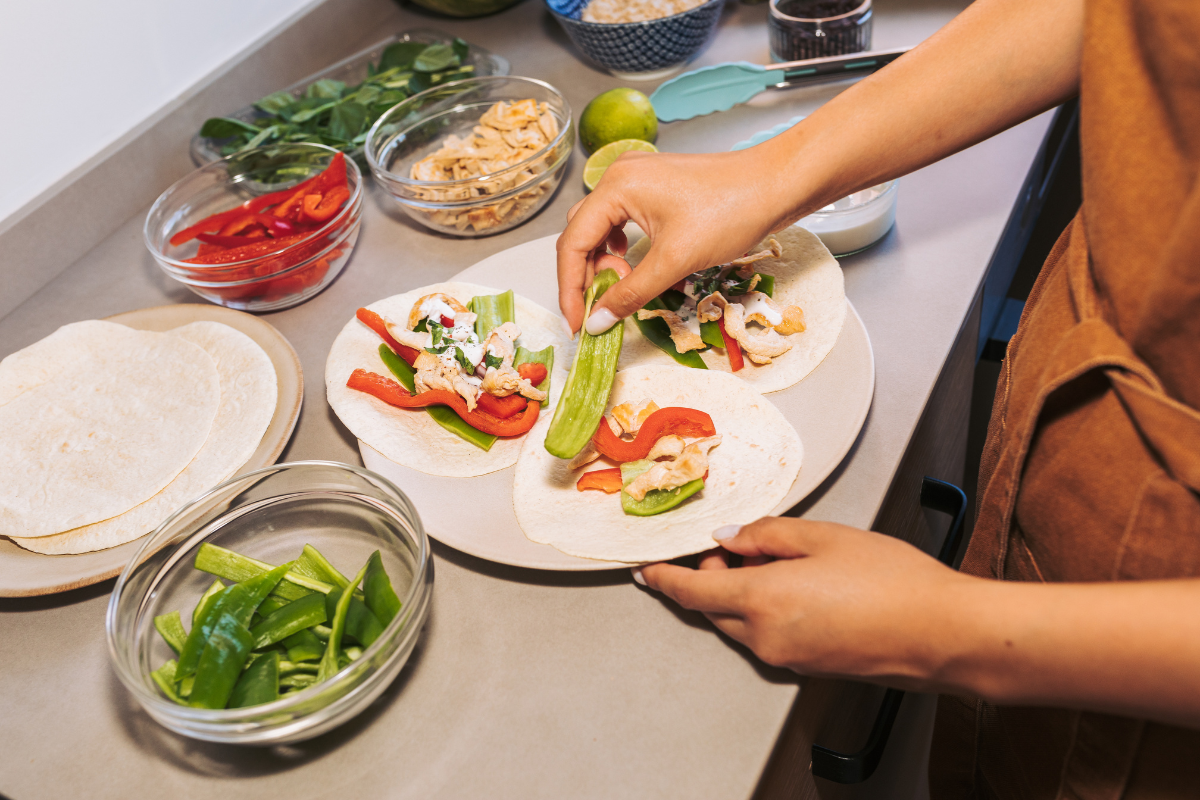 a woman in her kitchen meal prepping tortillas 